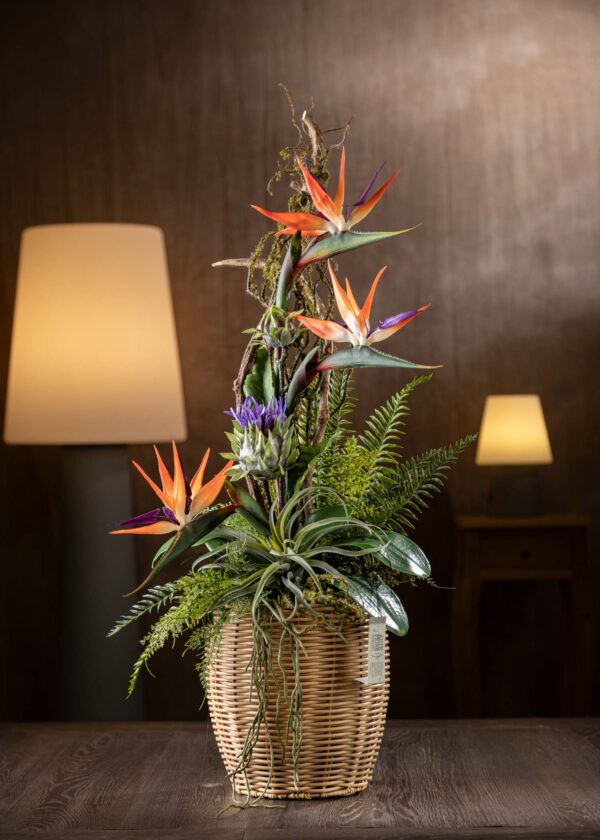 Vista frontale della composizione - Composizione di Sterlizie finte in vaso di vimini con fiori artificiali realistici.