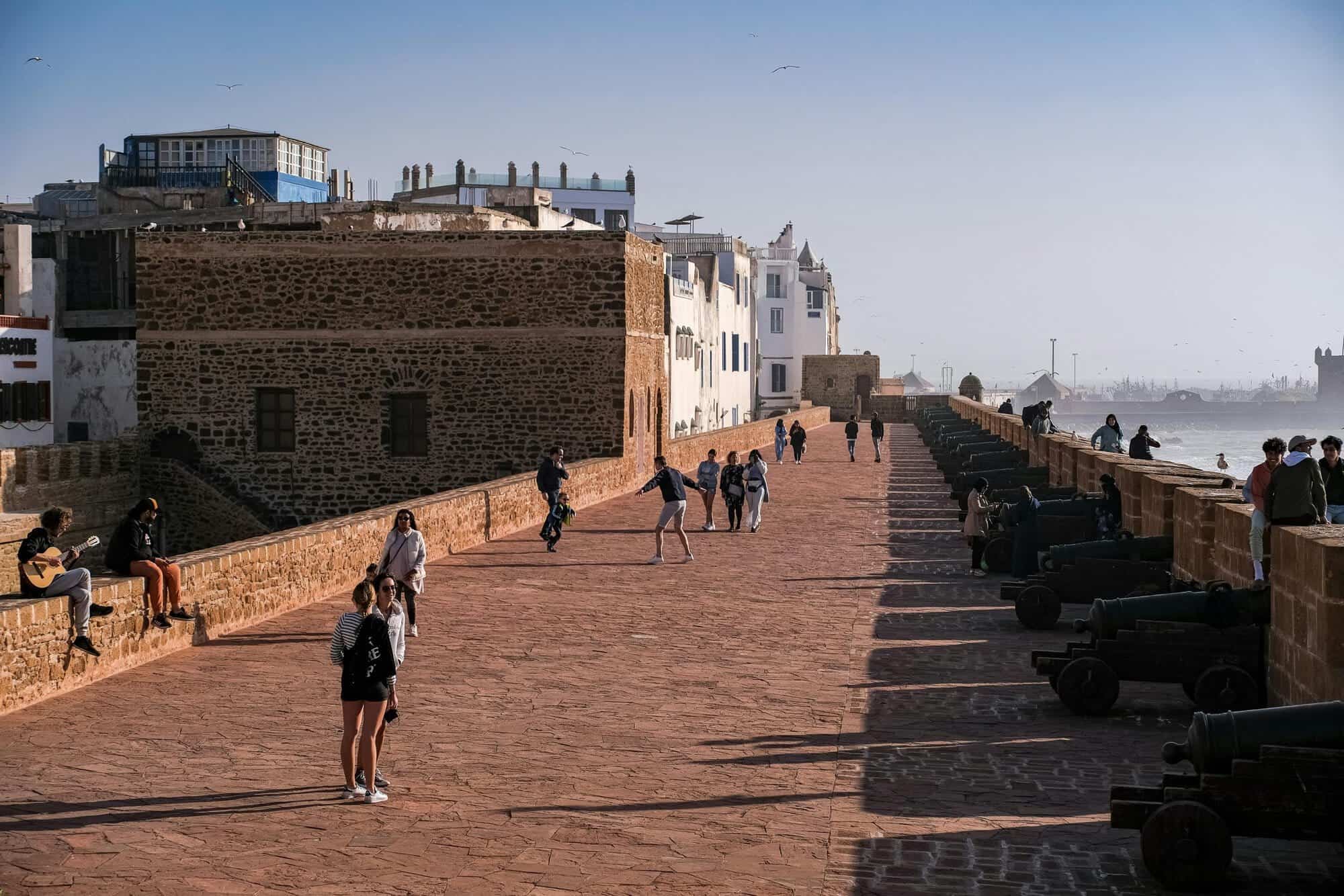Paseo por la muralla de Essaouira con vistas al mar y a la ciudad antigua.