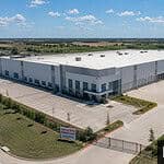 Bridge Loans for Commercial Real Estate: The 2026 Investor's Guide Aerial view of a large industrial warehouse under new ownership