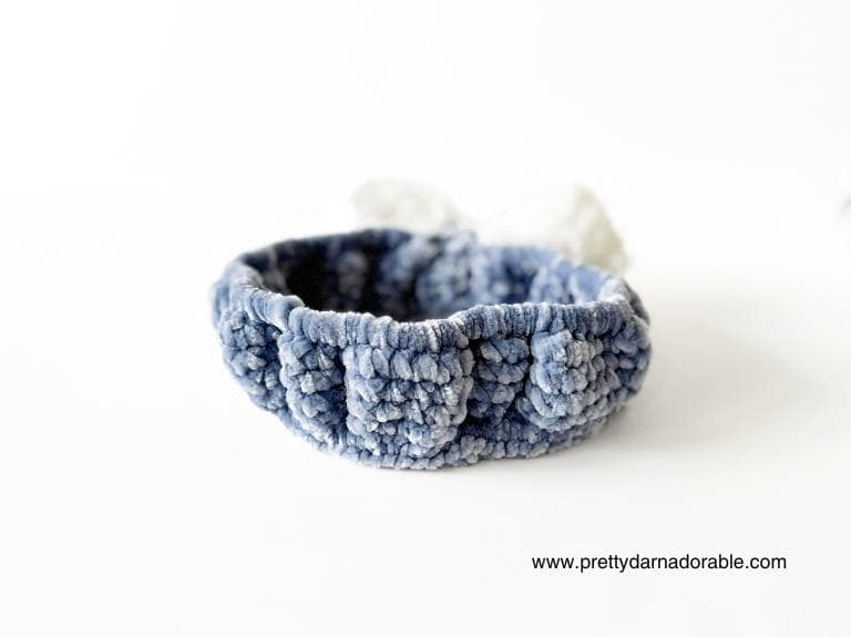 back view of blue crochet face wash headband with bow