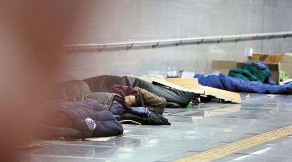 Homeless people sleep near Seoul Station in Jung District, central Seoul.