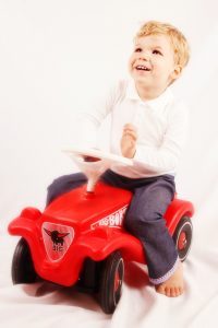 Mașină electrică pentru copii GOKID! Copil fericit pe mașină electrică pentru copii GOKID! în interior.