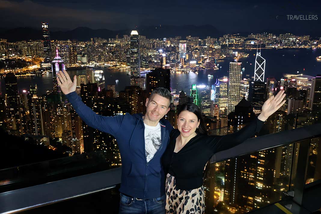 Die Reiseblogger Florian Westermann und Biggi Bauer auf der Aussichtsplattform auf dem Victoria Peak mit Blick auf Hongkong in der Nacht