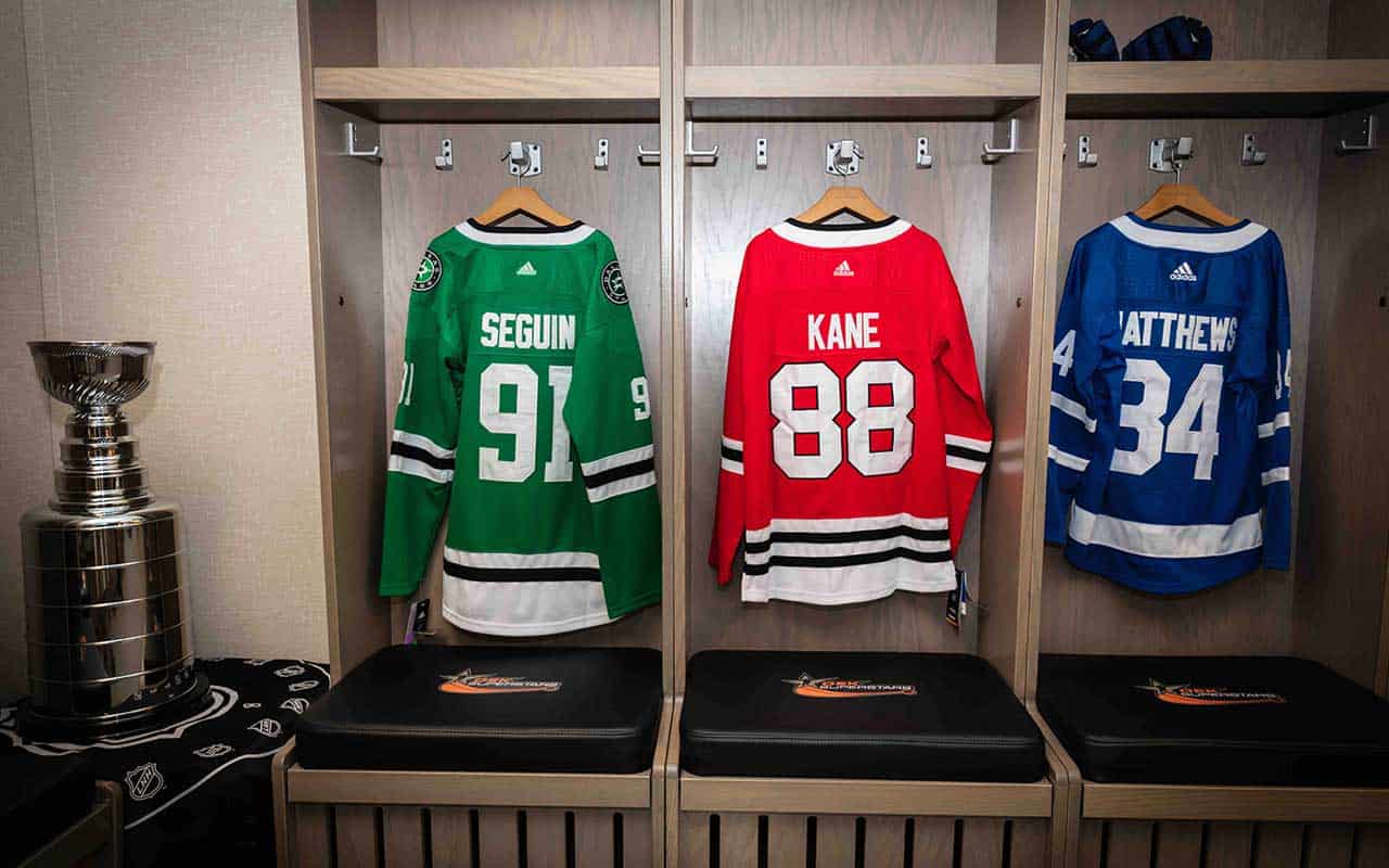 Three hockey jerseys labeled Seguin 91, Kane 88, and Matthews 34 hang in lockers; a Stanley Cup trophy is placed on the left side.