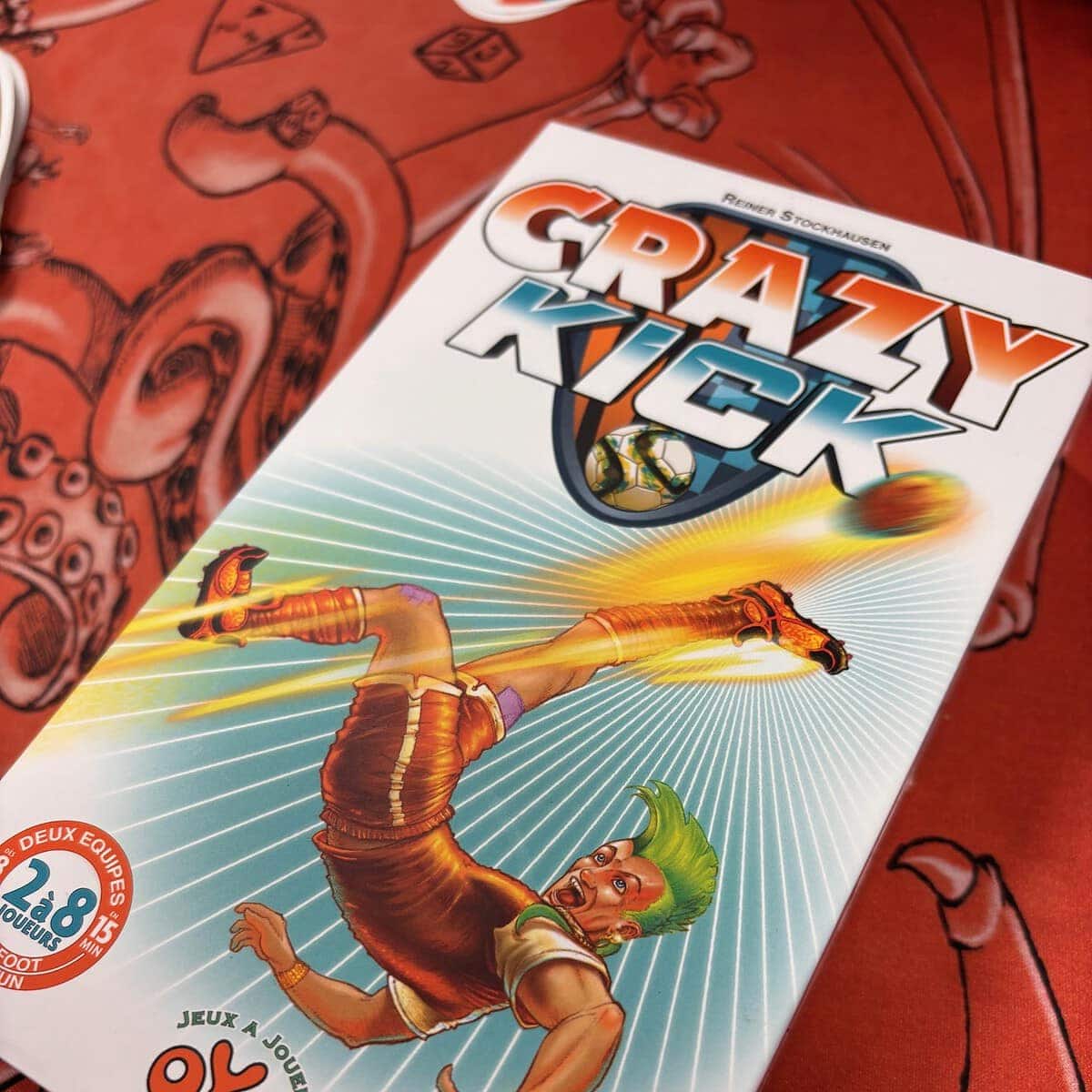 Barre de jeu vidéo Crazy Kick, conception graphique dynamique avec un personnage en pleine action, ambiance compétitive, mise en scène colorée pour les amateurs de jeux de société et d'esport.