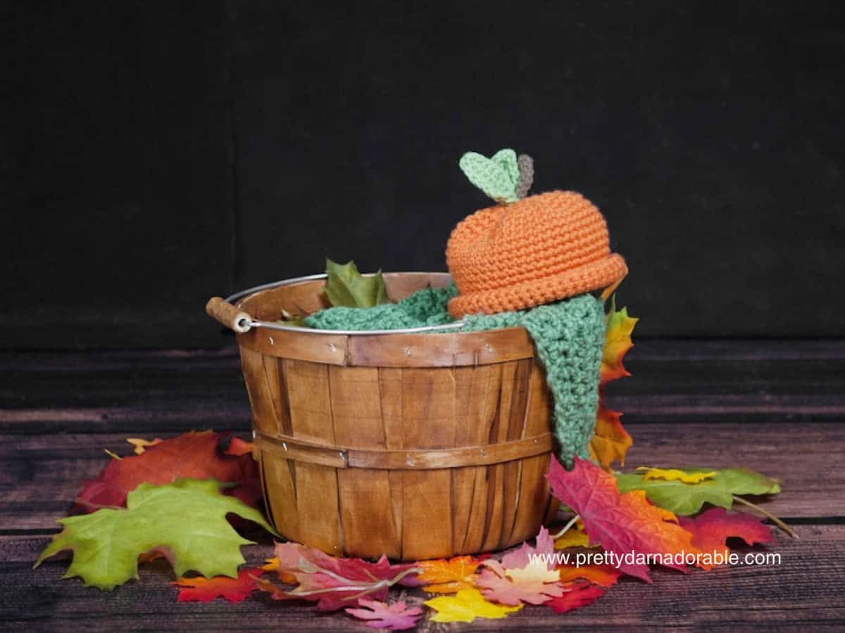crochet pumpkin hat sitting on a basket. Free crochet pumpkin hat pattern and video