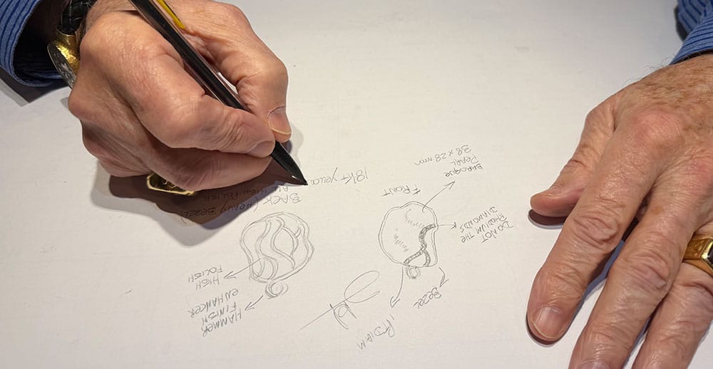 a jeweler designing custom jewelry with a pencil
