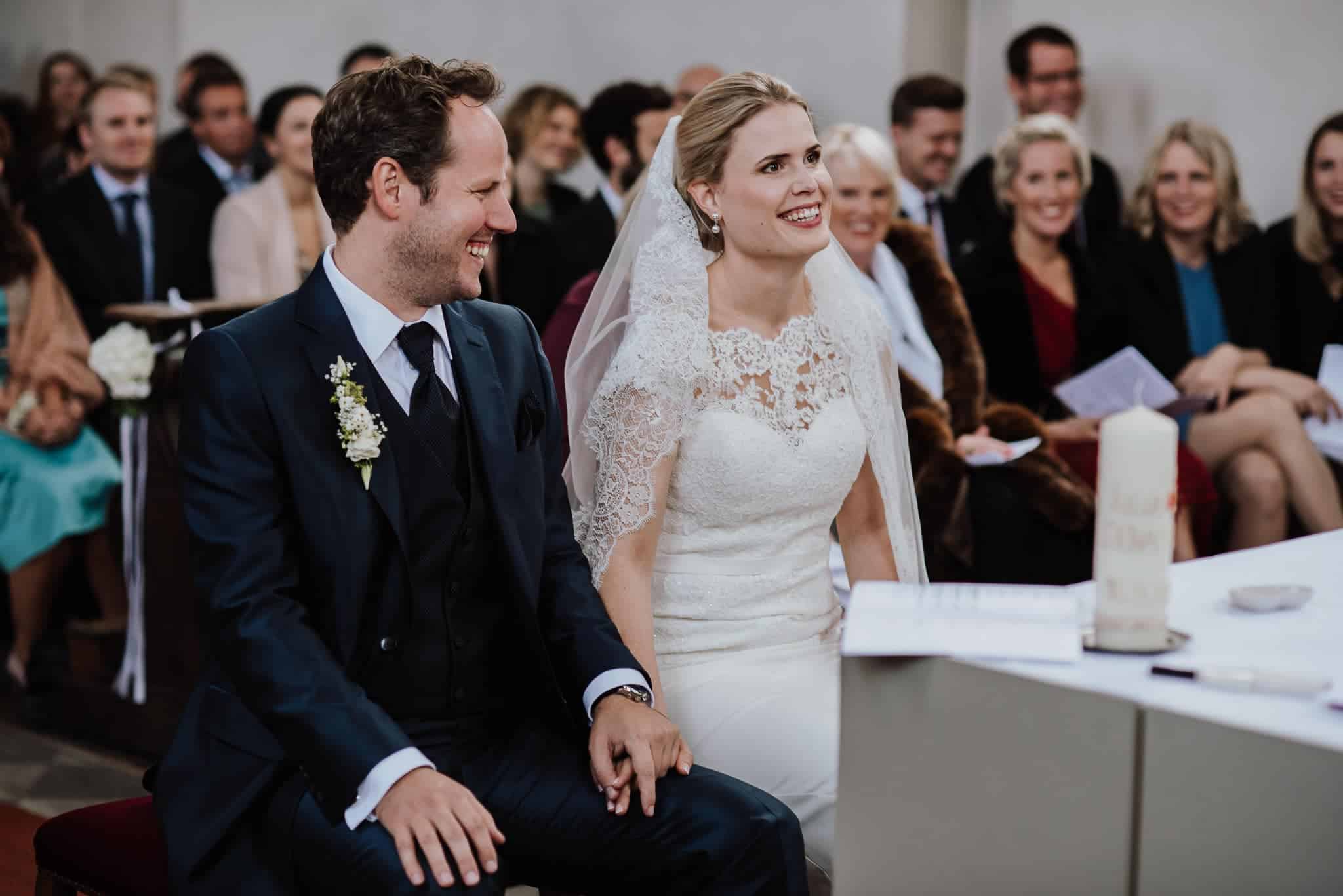 Brautpaar hält sich während der Trauung in der Kirche an den Händen – Hochzeitsfotografin Köln fängt den Moment ein.