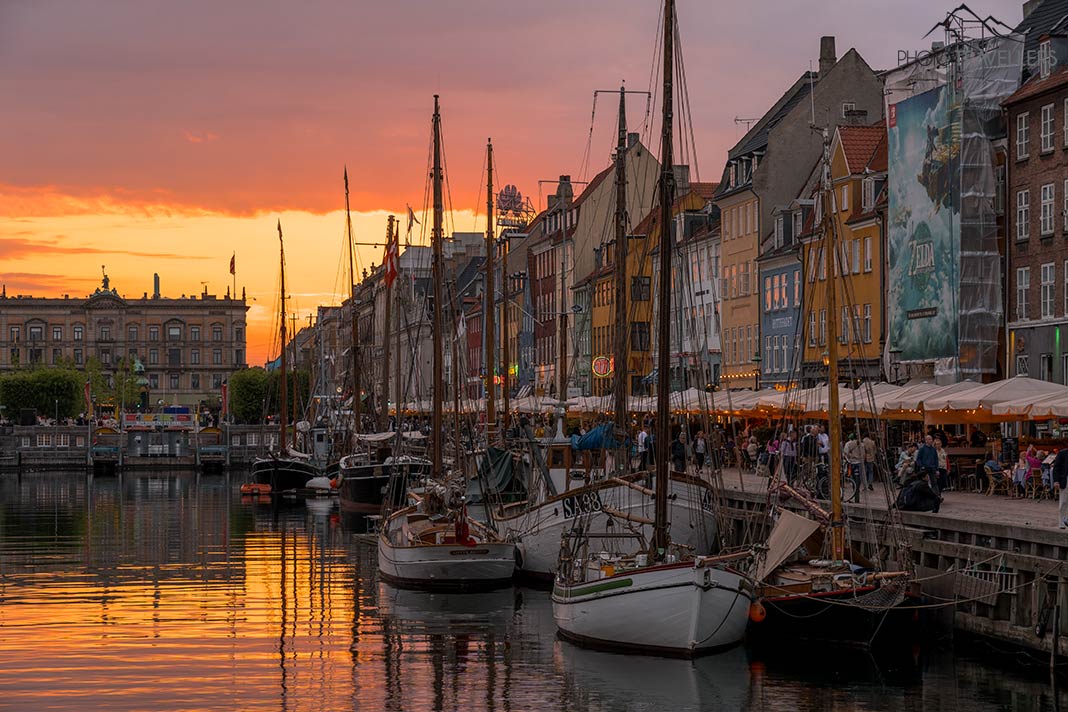 Der Blick am Abend über den Neuen Hafen in Kopenhagen mit vielen Schiffen am Ufer
