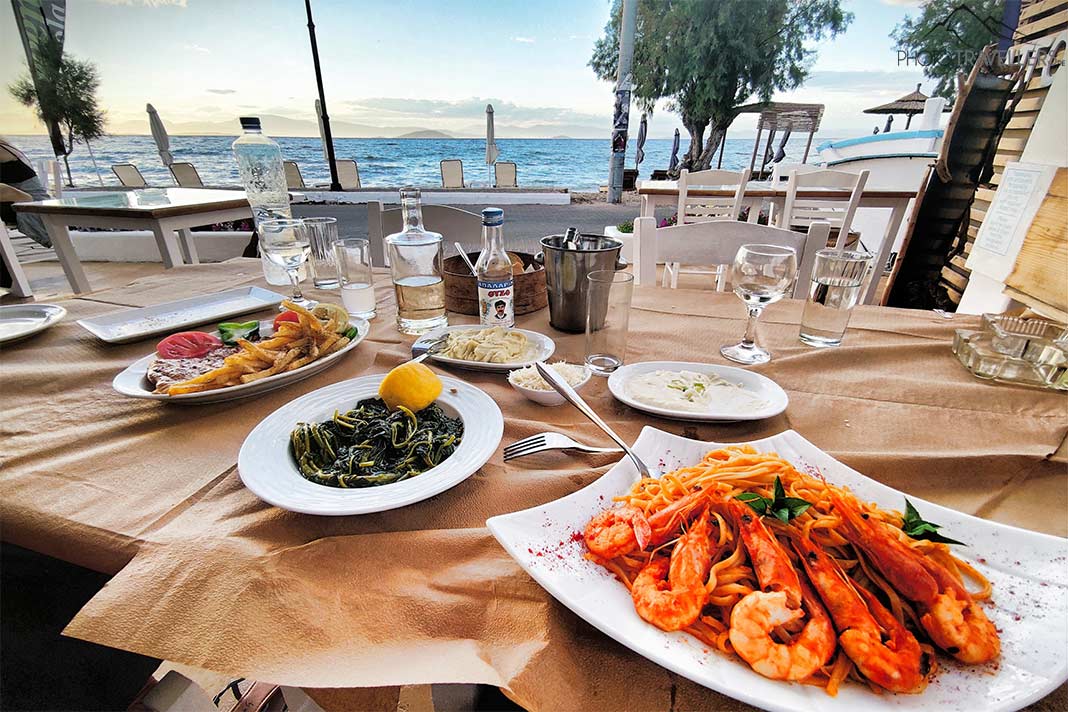 Ein gedeckter Tisch mit Shrimps und Gemüse in einer Taverne am Meer