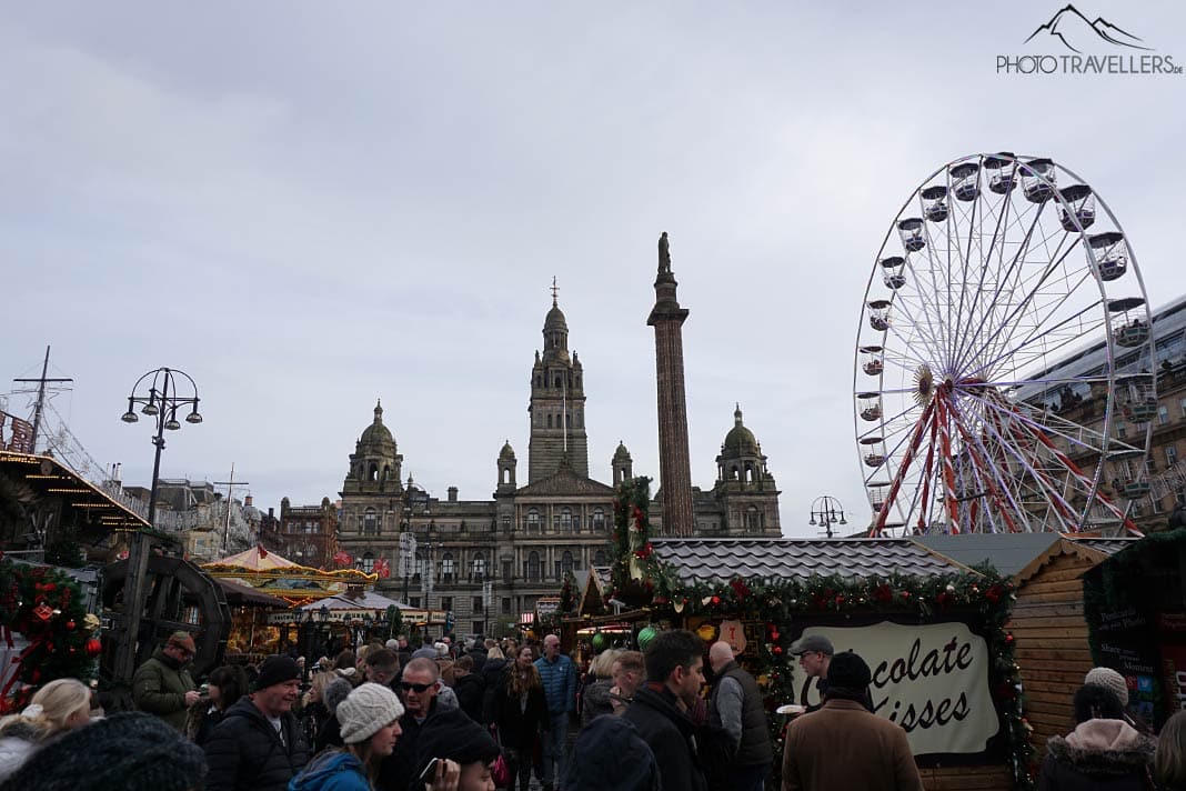 Der Weihnachtsmarkt auf dem George Place in Glasgow, im Hintergrund sieht man das Rathaus und ein Riesenrad