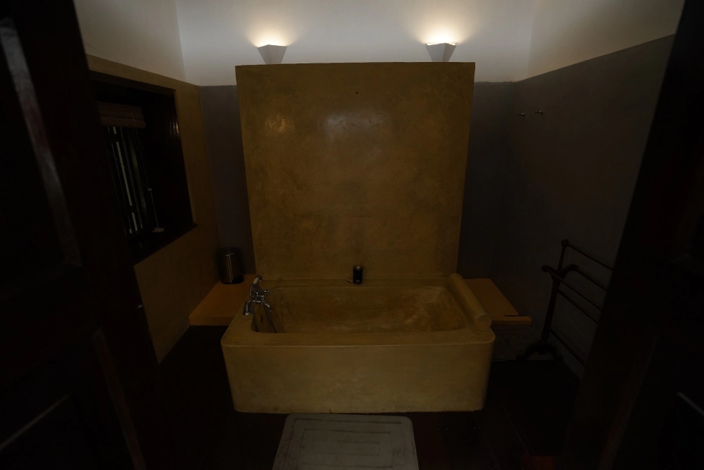 A view of the bathroom in Adigar's Manor's Connelian room, equipped with a bathtub and a toilet.