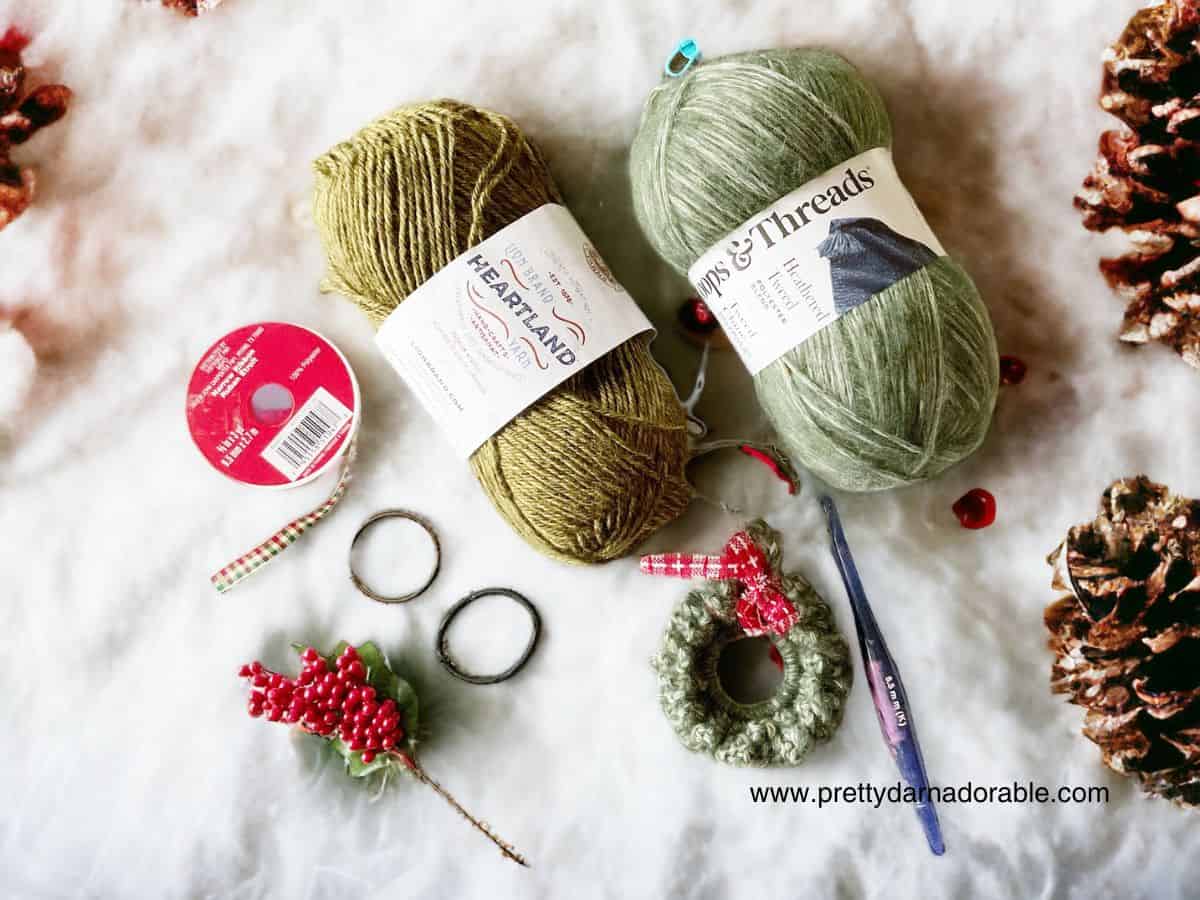 two skeins of green yarn ribbon and mini crochet wreath