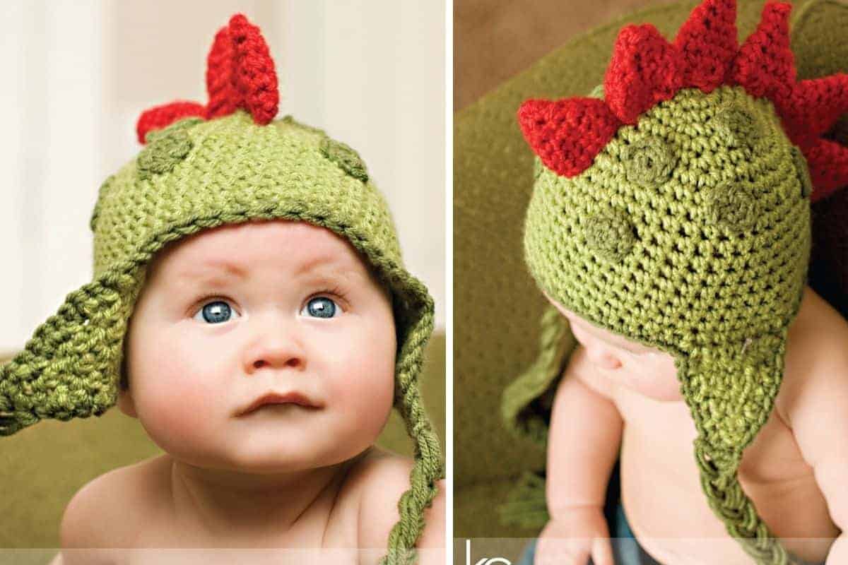 A baby wears a green crochet dinosaur hat featuring red spikes and ear flaps. Free crochet pattern