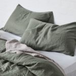 A person sitting on the side of a bed