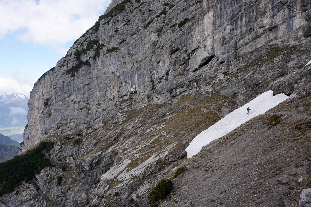 Ein Wanderer auf einem steilen Schneefeld auf dem Höttinger Schützensteig