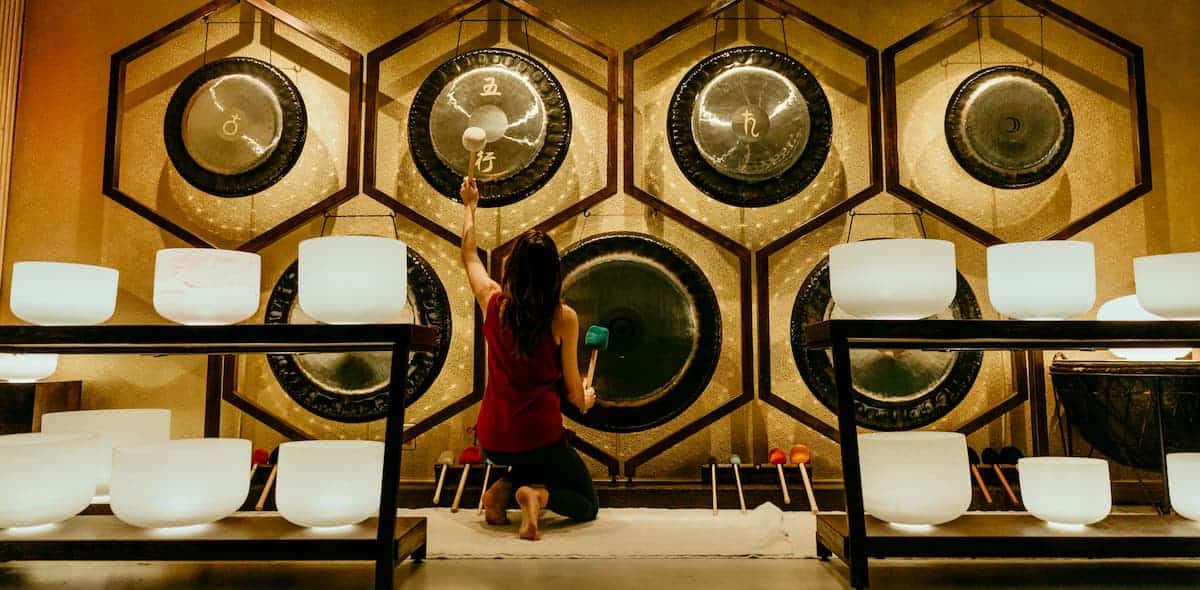 Jamie Bechtold playing two gongs at The Soundbath Center