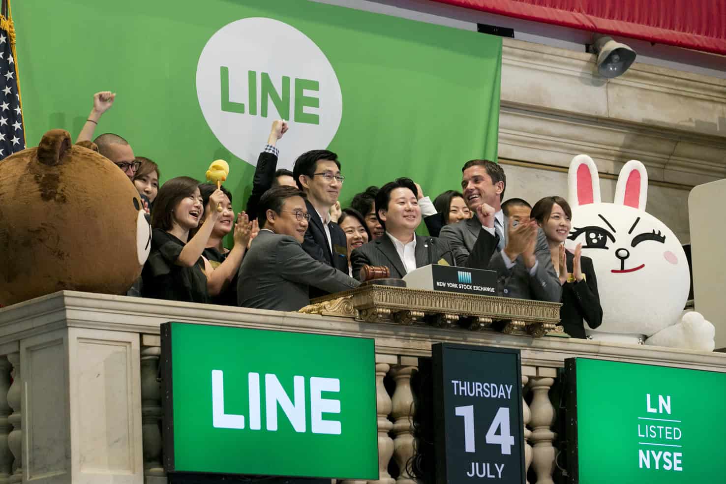 Executives with Japanese messaging app Line ring the opening bell for their company's IPO at the New York Stock Exchange, Thursday, July 14, 2016, in New York. Though little known in the U.S., Line has enjoyed a quick surge to popularity in Japan, filling an important communications hole after a devastating earthquake and tsunami in 2011 damaged phone infrastructure. In its home country, Line has more users than Facebook or Twitter. (AP Photo/Richard Drew)