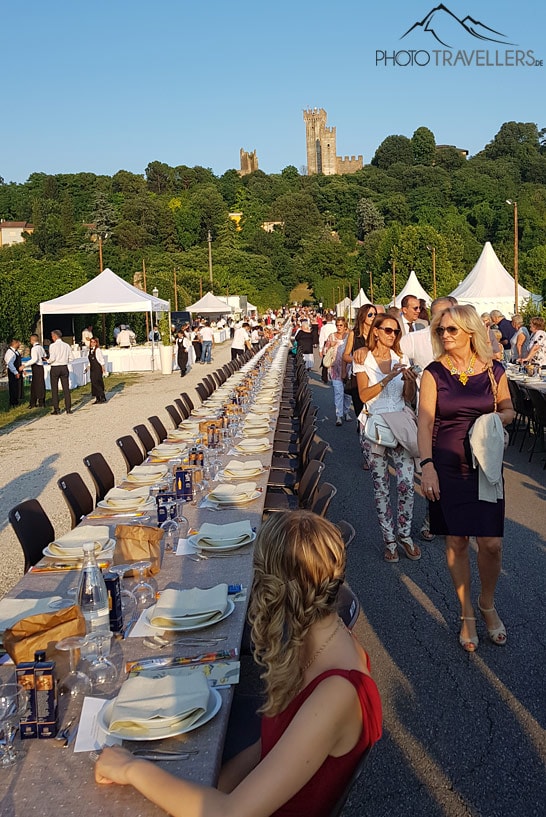 Die lange Festtafel zum Tortellini-Fest in Borghetto mit der Burg im Hintergrund