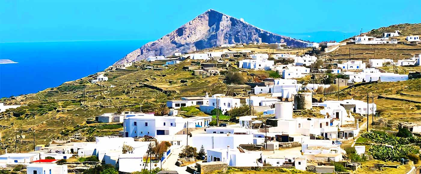Die pyramidenförmigen Felsen von Folegandros mit den weißen Häusern der Chora im Vordergrund
