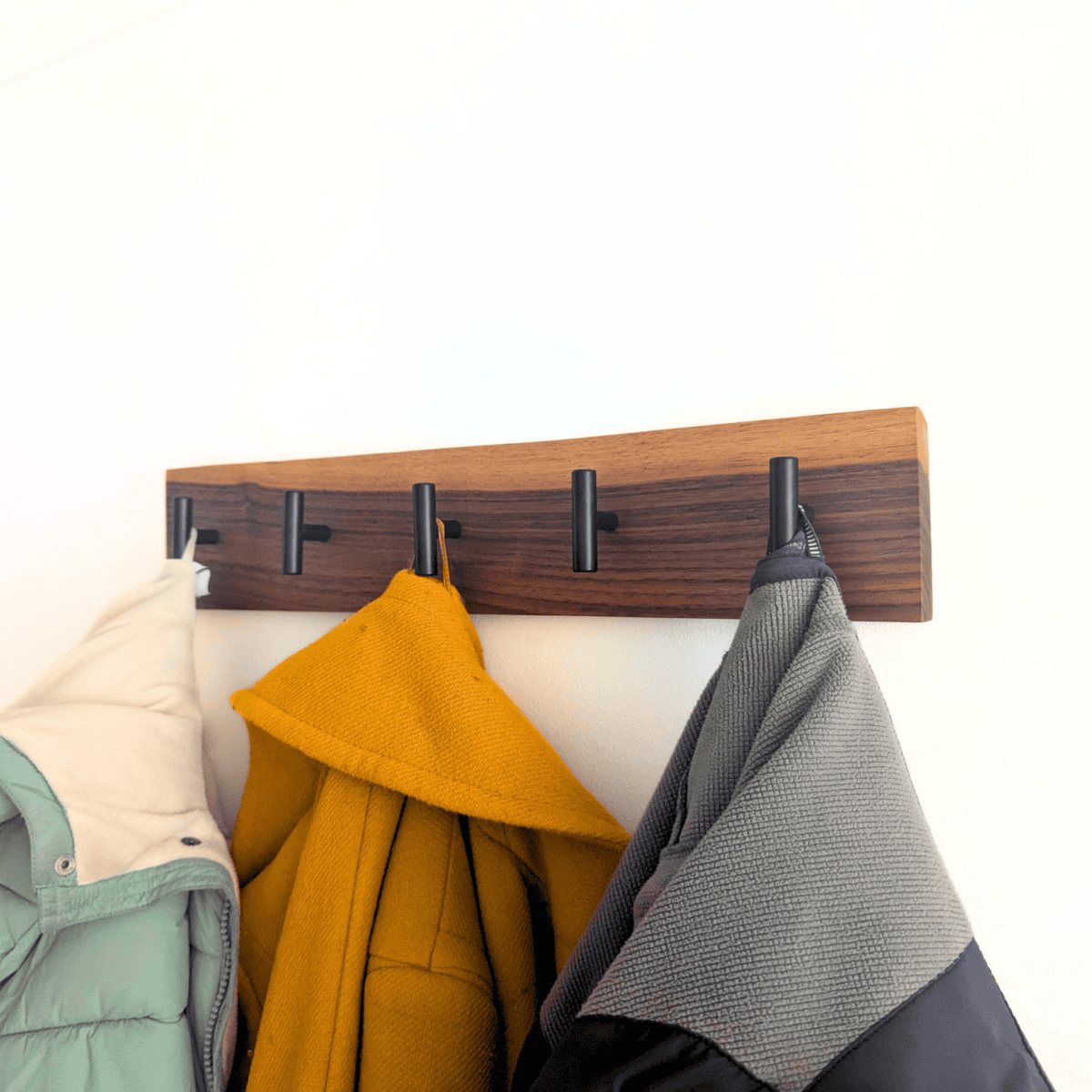 Modern Solid Black Walnut Coat Rack with Customizable Hooks - angled view with coats