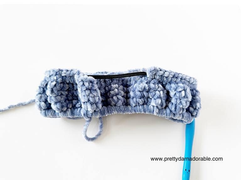 back view of blue crochet face wash headband with elastic showing