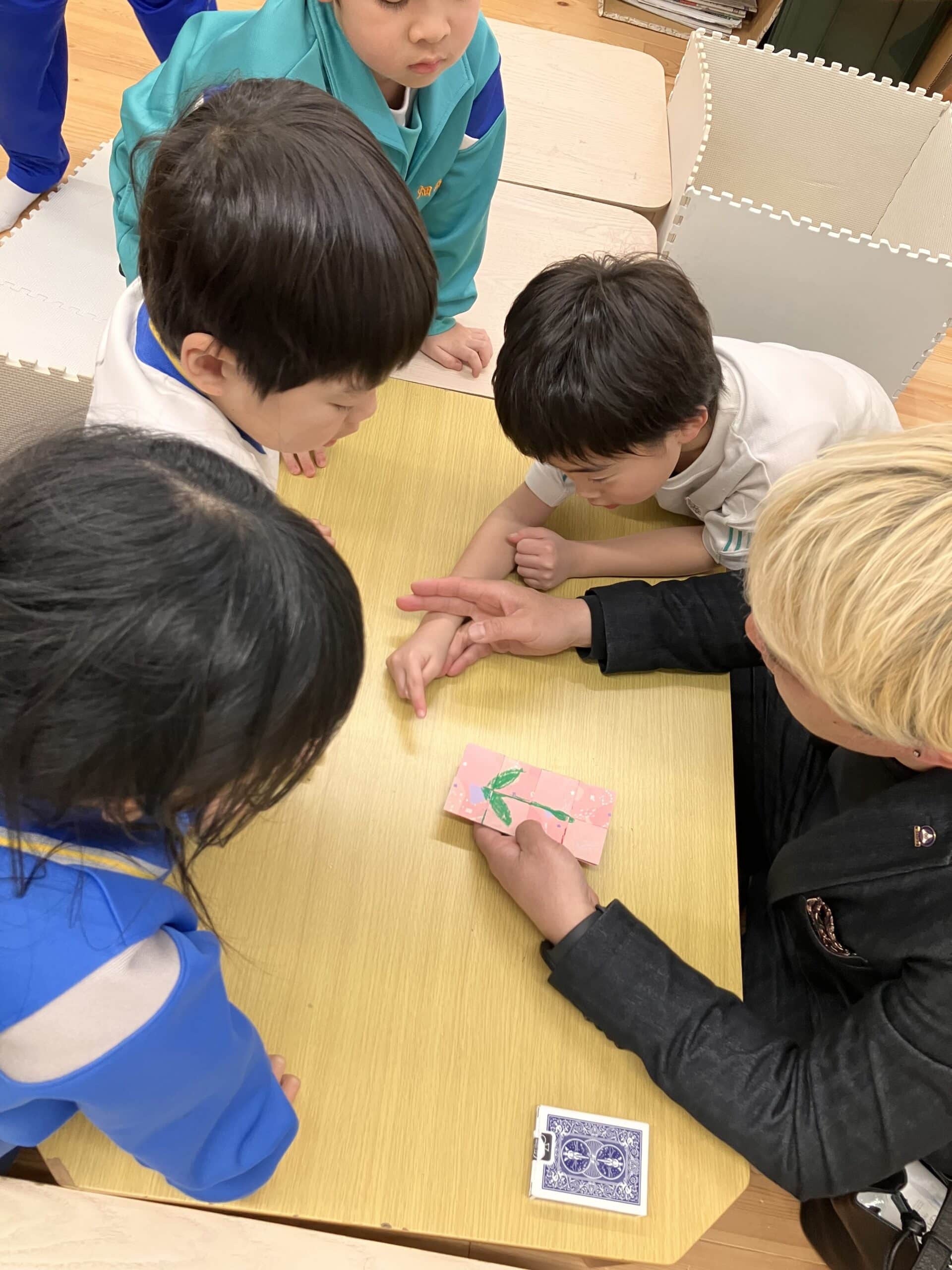 学童保育でマジックショー!折り紙マジックに40分かけて挑戦した子どもたち 4 チューリップの絵が描かれたカードを使ったマジックを披露するコンプレッサー