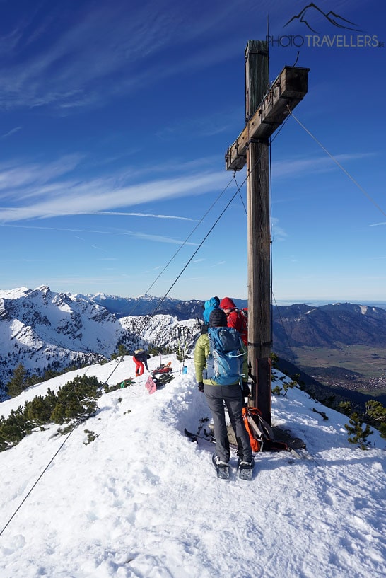 Reisebloggerin Biggi Bauer mit anderen Wanderern am Simetsberg-Gipfel mit dem Gipfelkreuz im Winter