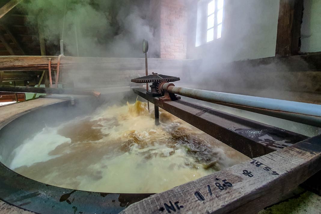 Im offenen Sudkessel wird die Würze eingekocht und es dampft im gesamten Brauhaus