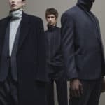 A group of people standing next to a man wearing a suit and tie