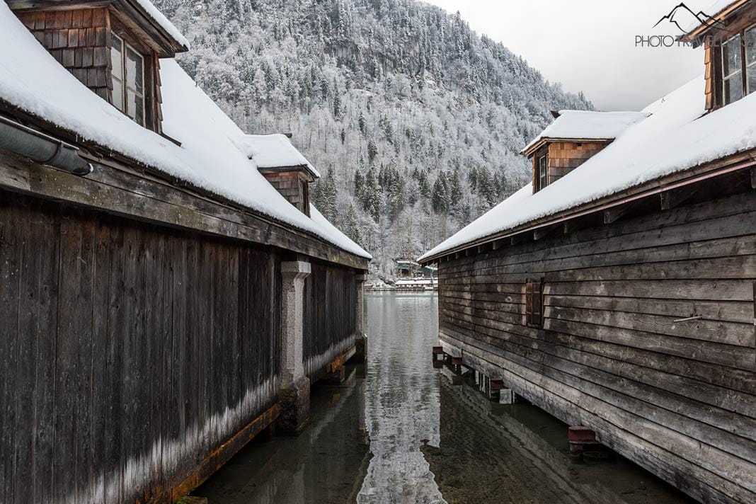 Zwei verschneite Bootshäuser am Königssee