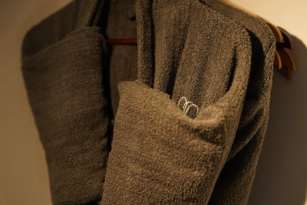 Robes hanging on hangers in the monkey puzzle room of Adigar's Manor.