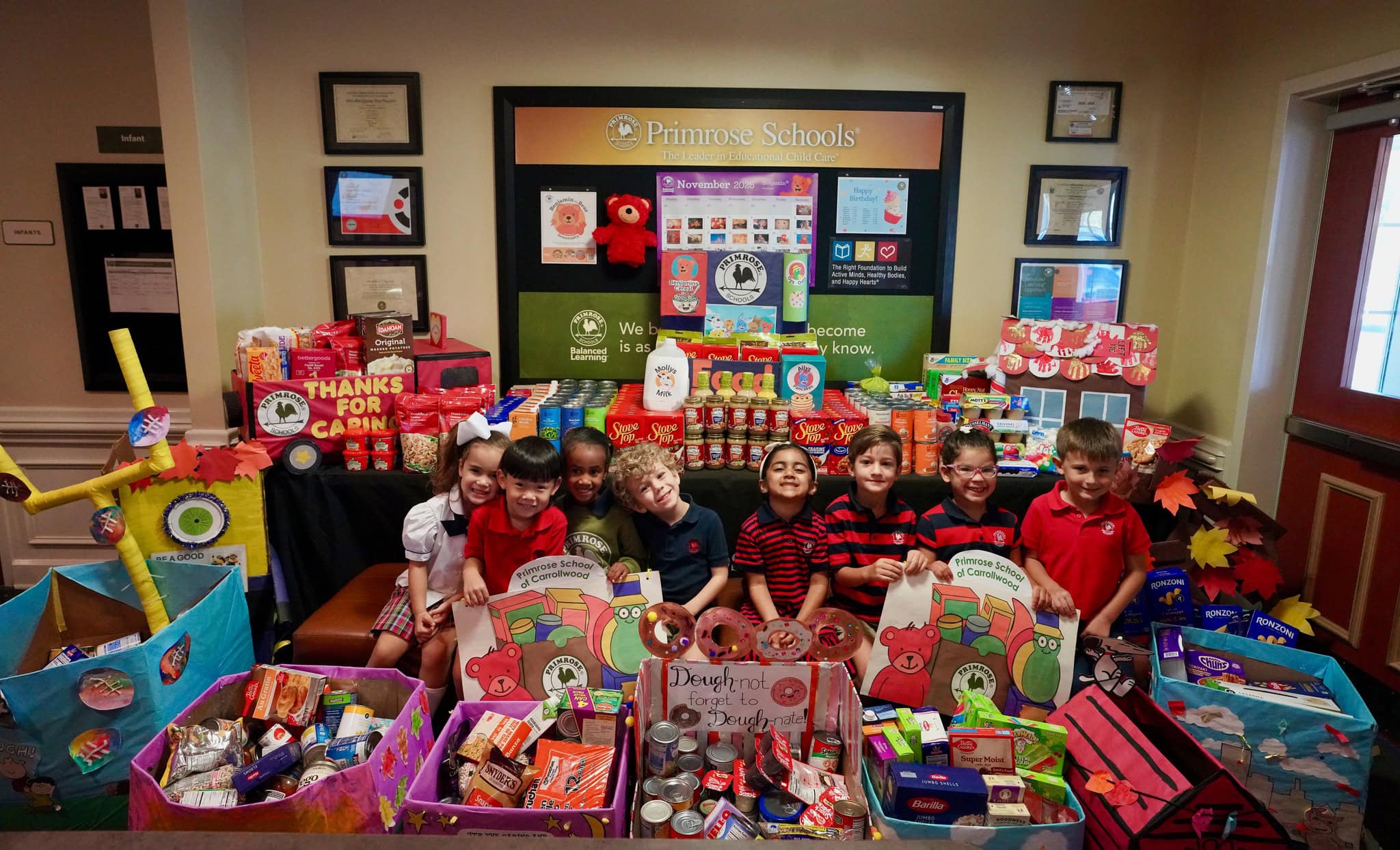 Primrose students pose with collected food donations at school during the Caring and Giving Food Drive