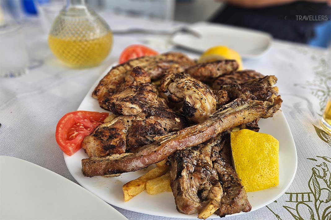 Grillplatte mit verschiedenen Fleischsorten mit ZItrone und Tomate auf einem Teller