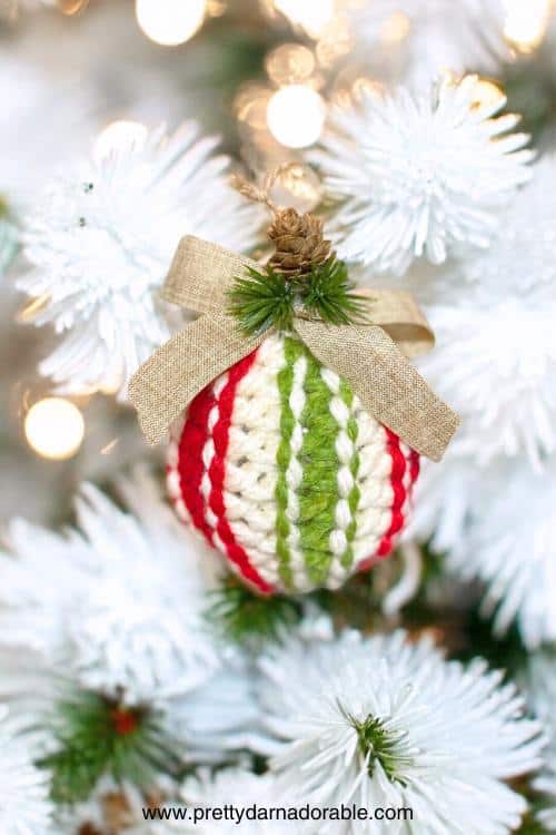 a green and white christmas ornament hanging from a tree