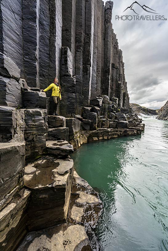 Reisebloggerin Biggi Bauer mit einer gelben Jacke im Stuðlagil Canyon in Island