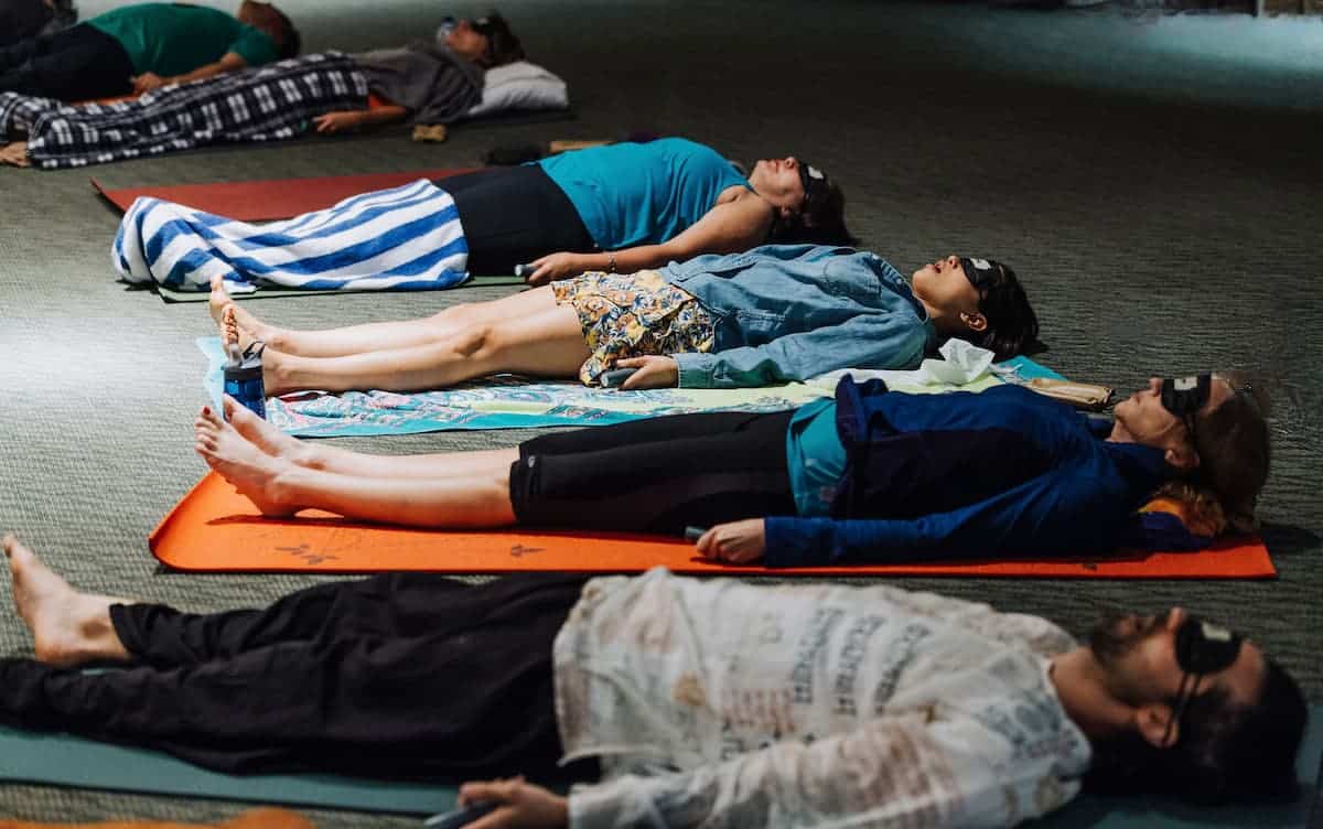 Group of people lying on their backs receiving a sound bath