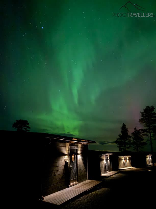 Polarlichter über Hütten in Finnland