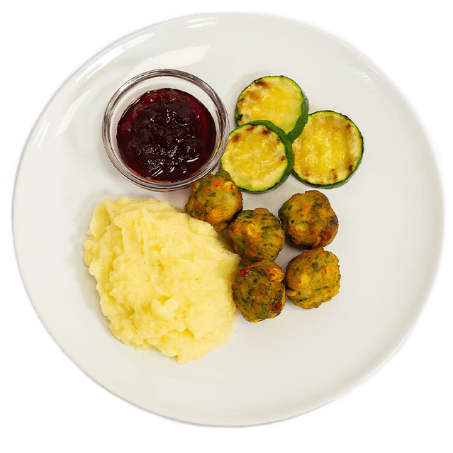 Ein weißer Teller mit Gemüsebällchen, einer Portion Kartoffelbrei, gebratenen Zucchini-Scheiben und einer kleinen Schale Preiselbeermarmelade.