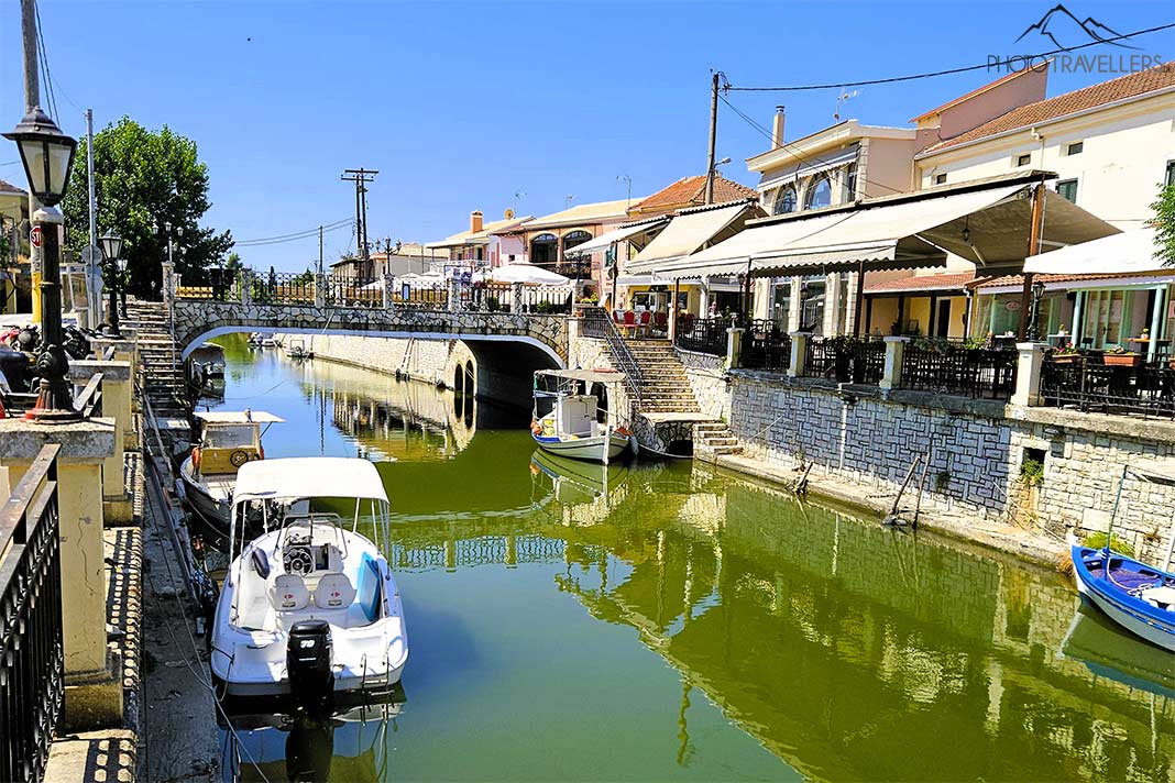 Boote und Lokale säumen das Ufer des grün schimmernden Kanals in Lefkimmi