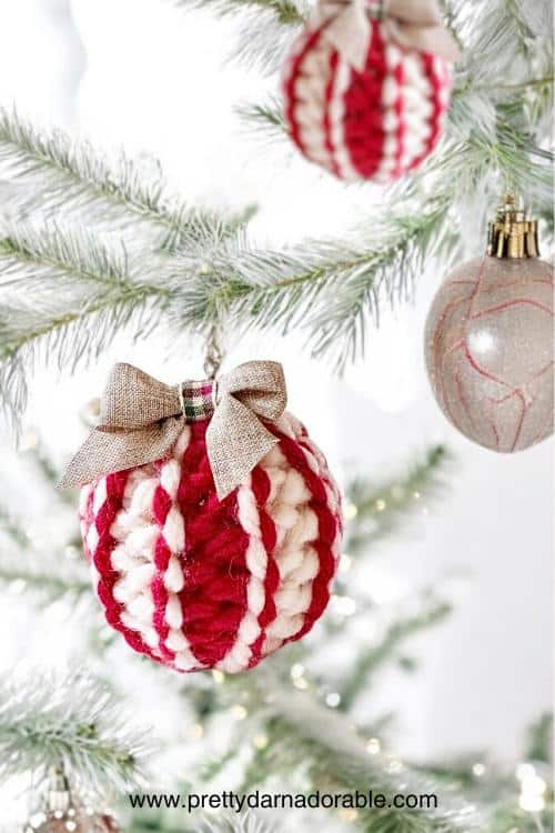 a red and white christmas ornament hanging from a tree