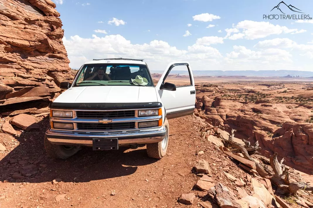 Ein weißer Chevrolet Suburban auf einer einspurigen Schotterpiste im Monument Valley