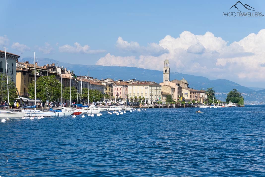 Der Blick über den Gardasee auf den schönen Ort Salò mit der großen Kirche und den Gardaseebergen im Hintergrund