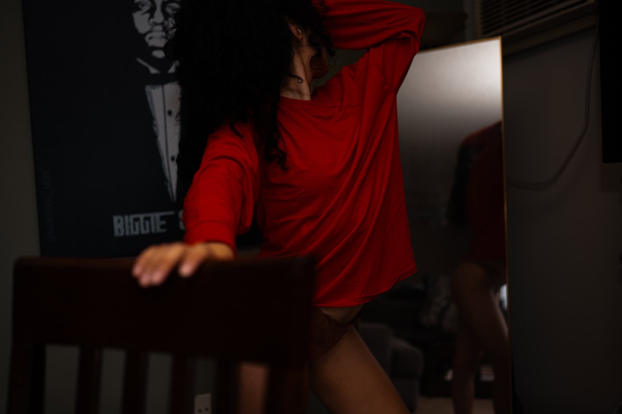 Anonymous Christmas Boudoir Session in a red shirt looking into a mirror in Los Angeles Studio