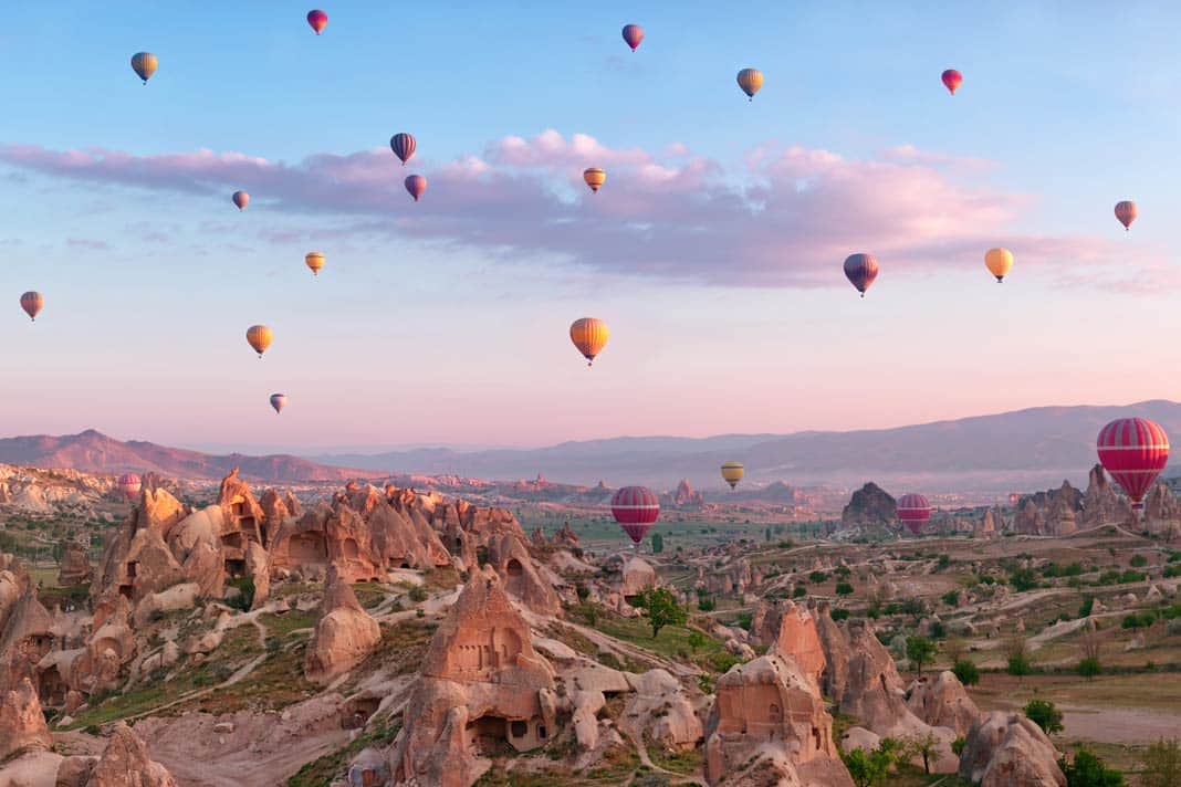 Heißluftballons am Morgen über den Felsenwohnungen von Kappadokien
