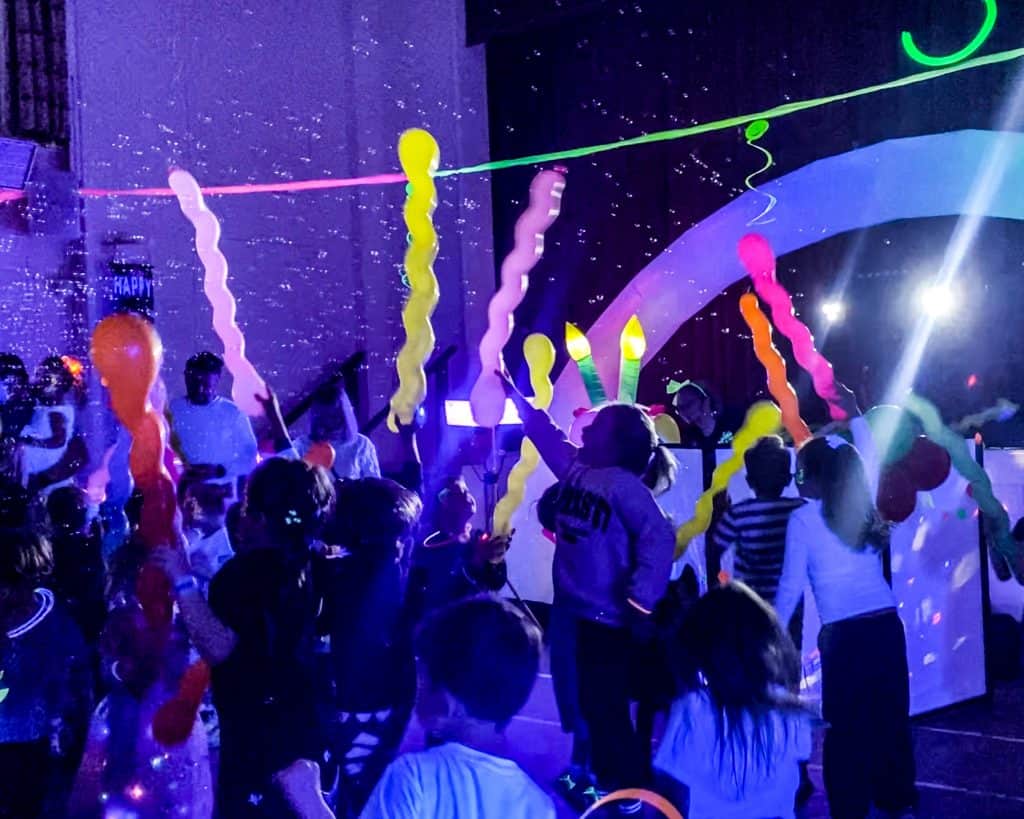 Glow UV Disco Birthday Party in Sandhurst | Treasure Box Parties - Childrens Party Entertainers | Surrey Hampshire and Berkshire | Treasure Box Parties An exciting UV glow disco party in Sandhurst with vibrant lighting, music, and children having fun under neon effects.