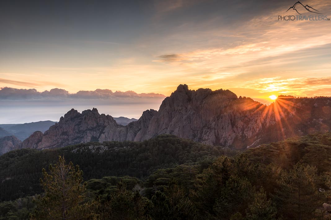Die Sonne steigt am Morgen über ein Bergmassiv auf Korsika