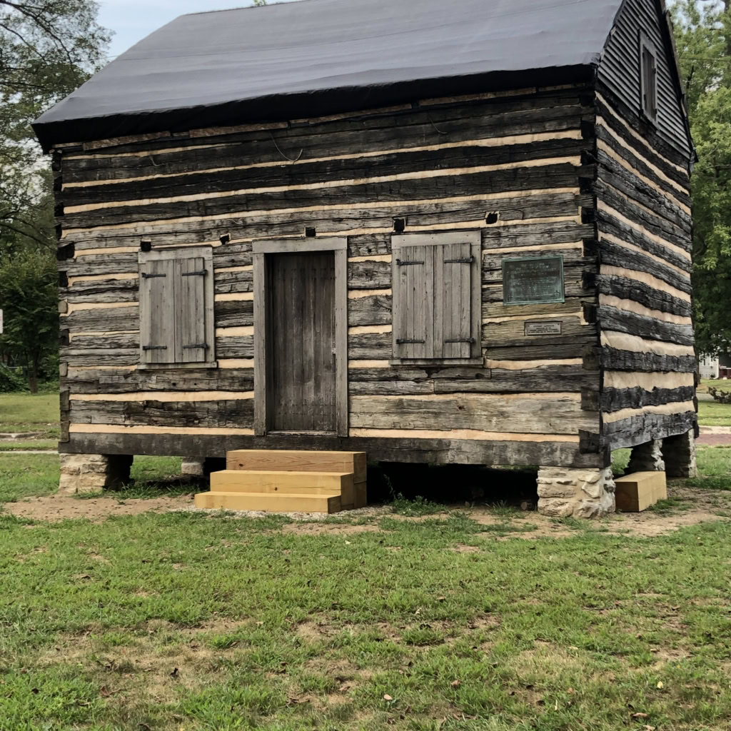 Weathered historic log cabin at The History Museum, showcasing early American pioneer architecture.