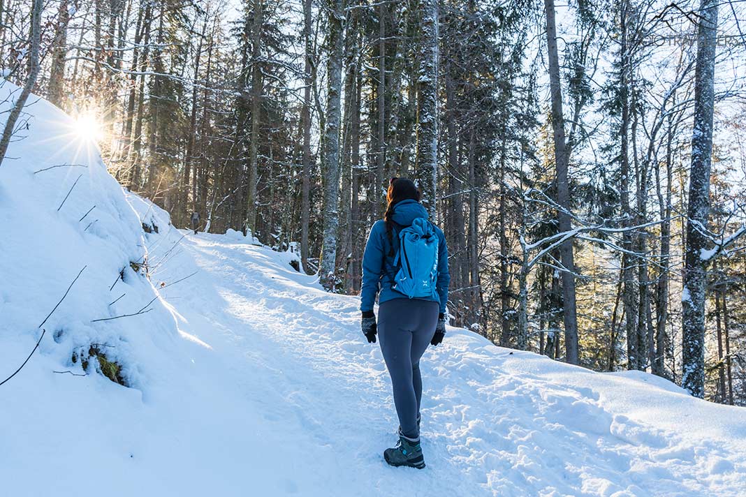 Reisebloggerin Biggi Bauer wandert im verschneiten Bergwald nach oben