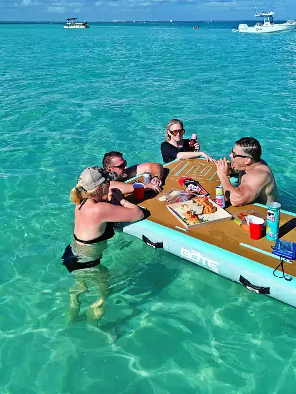 A group of people using BOTE floats as their table for lunch at Crab Island